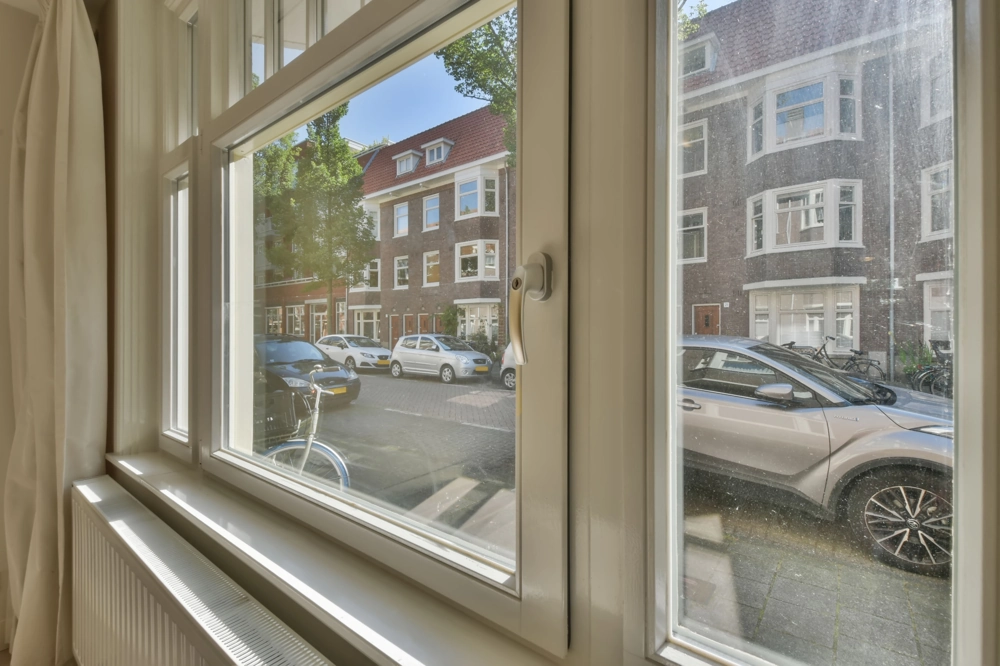 Innenansicht einer neuen weißen Fensterfront mit Heizkörper und Blick auf Straße (Fenstermontage)